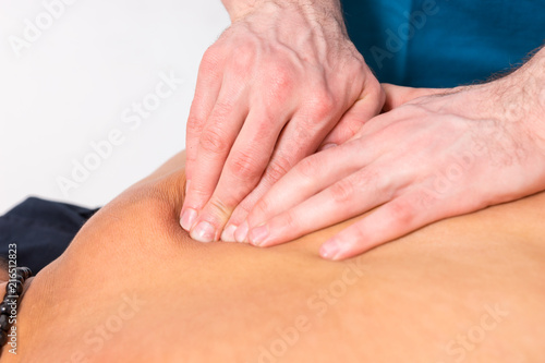 Professional masseur manipulating muscles