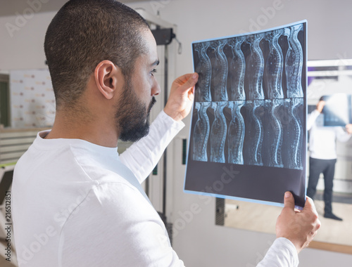 Obraz na płótnie Physiotherapist Looking at X-Ray Film of Spine w salonie