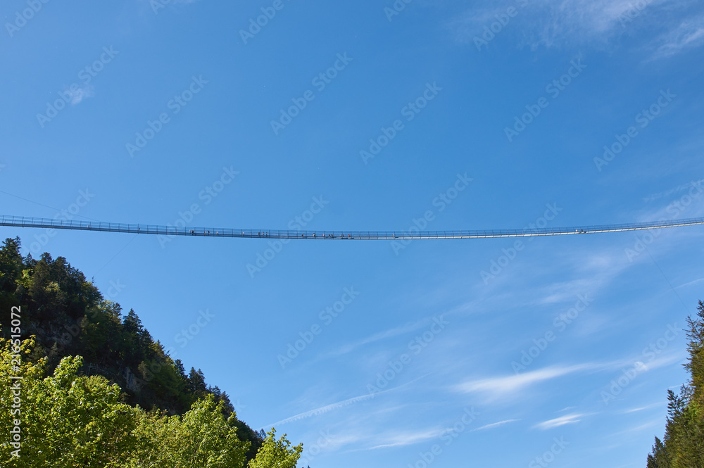 Suspension bridge over the precipice. Blue sky, people are standing. Germany, highline179. Suspension bridge over the precipice. Blue sky, people are standing. Germany, highline179.