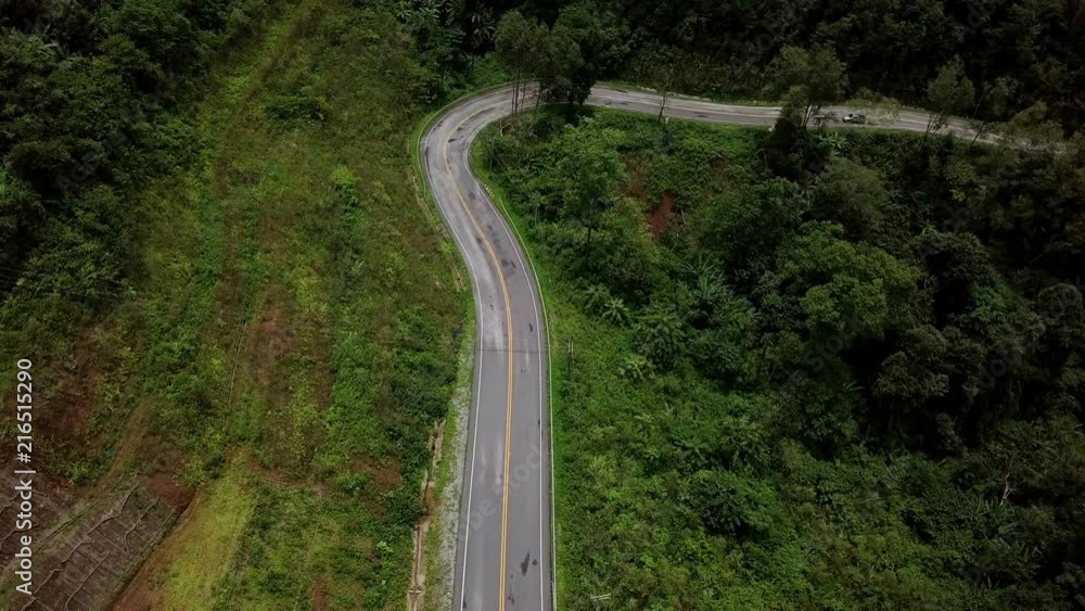Aerial view of a pick up truck driving on the countryside road surrounded by the beautiful Doi Phuka mountain forrest in Nan Province Northern Thailand Aerial view of a pick up truck driving on the countryside road surrounded by the beautiful Doi Phuka mountain forrest in Nan Province Northern Thailand