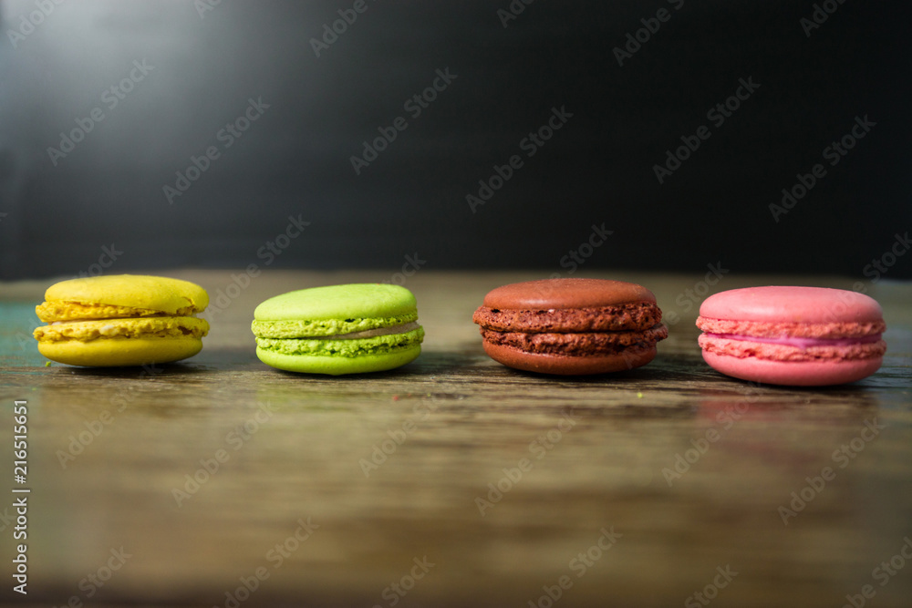Cake macaron or macaroon on wooden table with black background, sweet and colorful dessert Cake macaron or macaroon on wooden table with black background, sweet and colorful dessert