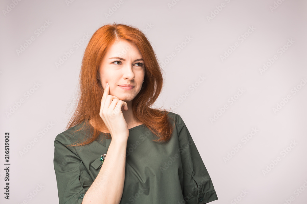 Attractive thinking red-haired woman on white background Attractive thinking red-haired woman on white background