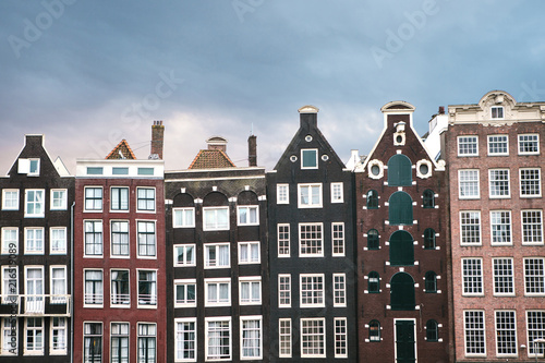 Traditional houses in Amsterdam in the Netherlands in a row against the backdrop of the setting sun.