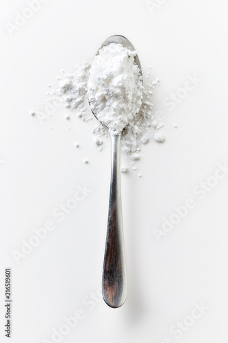 Spoon full of powder sugar on white, from above
