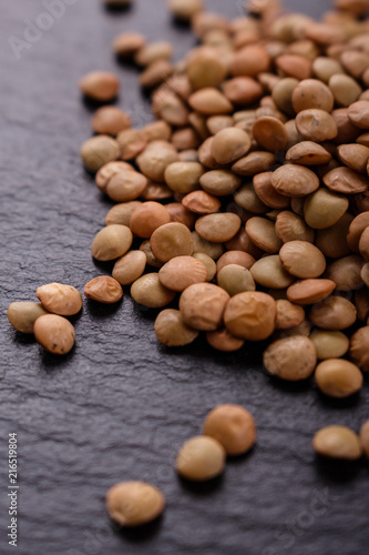 raw lentils on a dark stone background
