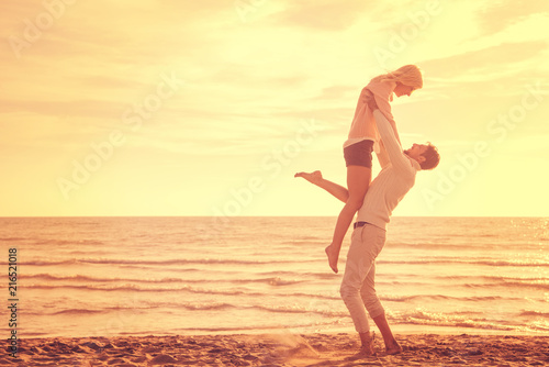 Loving young couple on a beach at autumn sunny day