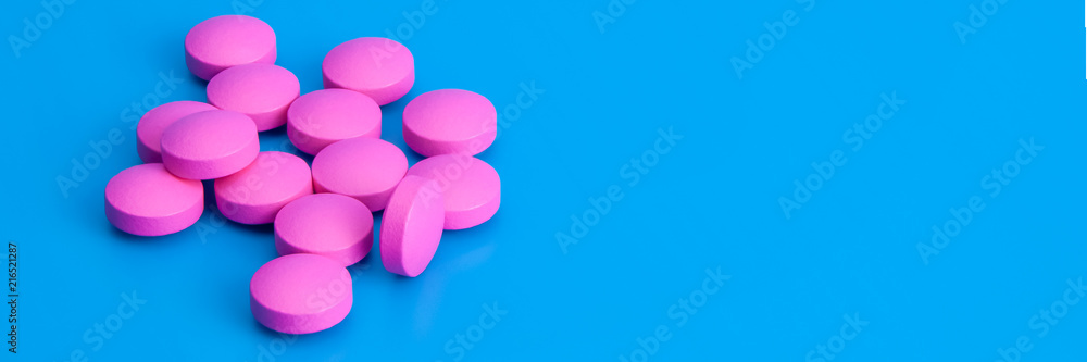 Bright large pink pills on a blue background. Bright large pink pills on a blue background.