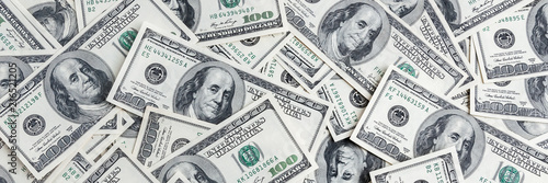 A pile of one hundred US banknotes. Cash of hundred dollar bills, dollar background image.
