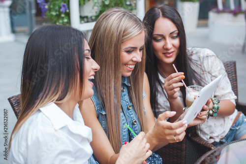 Group of cheerful women making online shopping outdoors