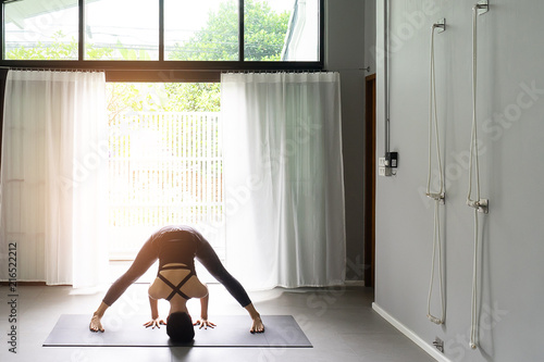 Asian young woman practicing yoga in gray background.Young people do yoga indoor.