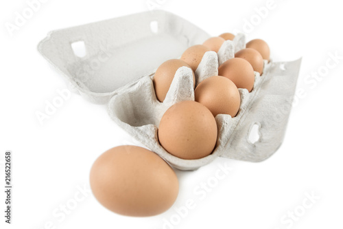 Brown eggs in a carton box, shot with low depth of field, isolated on white background