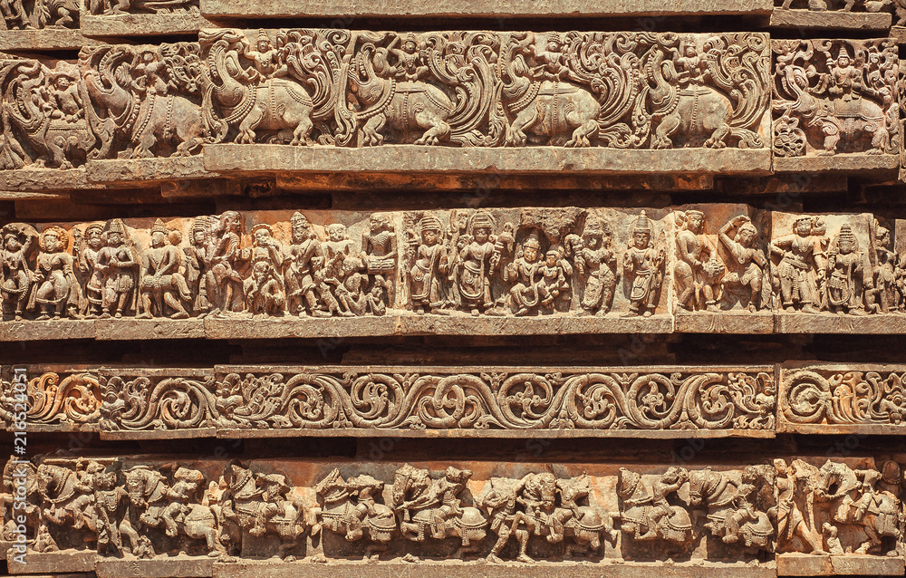 Facade of Indian temple with friezes narrating legends from the Hindu texts. Animals, people and patterns from 12th century, Halebidu, India