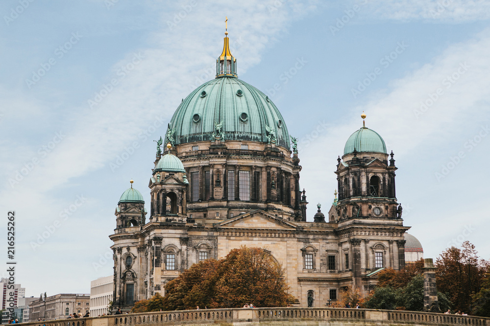 The Berlin Cathedral is called Berliner Dom against the blue sky. Beautiful old building in the style of neoclassicism and baroque with cross and sculptures. Berlin, Germany