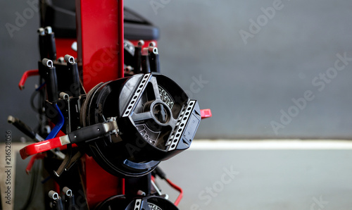 closeup wheel balancing machine at tyre service center with soft-focus and over light in the background photo