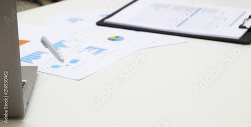 business chart on white wooden table with notebook and pen