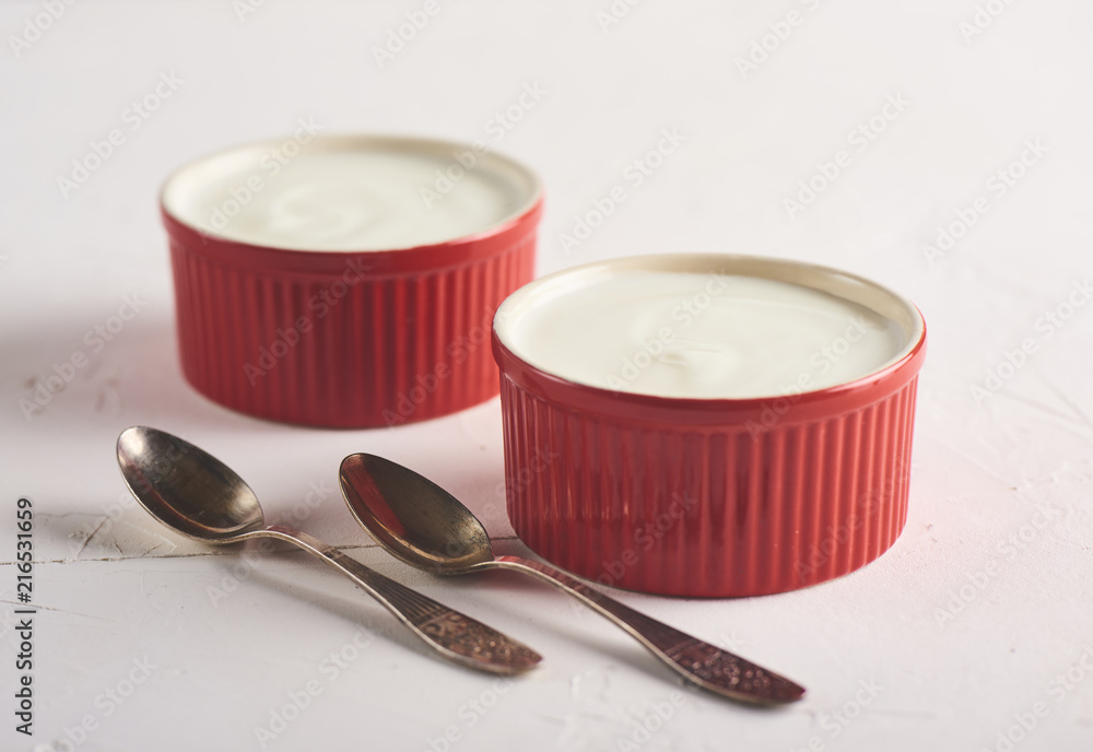 Homemade Greek yogurt or sour cream in a red bowl Homemade Greek yogurt or sour cream in a red bowl