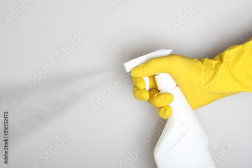 hand yellow glove and white bottle sprayer
