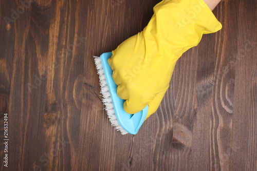 yellow glove and brush on a wooden background