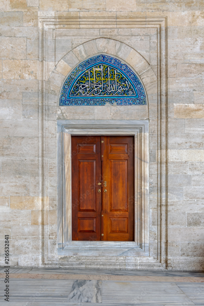 Wooden engraved door on stone wall and tiled marble floor, Sulaymaniye Mosque, Istanbul, Turkey Wooden engraved door on stone wall and tiled marble floor, Sulaymaniye Mosque, Istanbul, Turkey