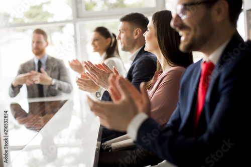 Businesspeople applauding while in a meeting at office