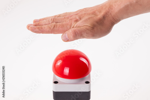 Hand pushing a red buzzer photo