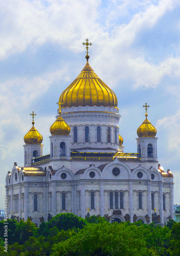 Moscow. The Cathedral of Christ the Savior against the background of a cloudy sky and green trees.