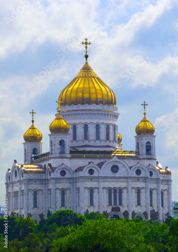 Moscow. The Cathedral of Christ the Savior against the background of a cloudy sky and green trees.