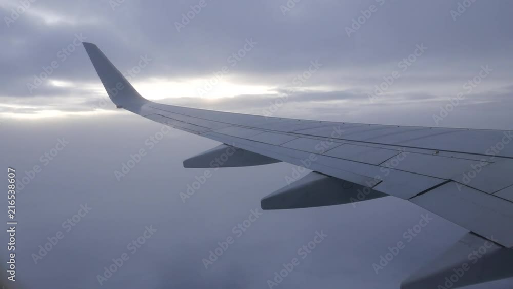 View from airplane with wing flying in the sky between layers of clouds. View from airplane with wing flying in the sky between layers of clouds.