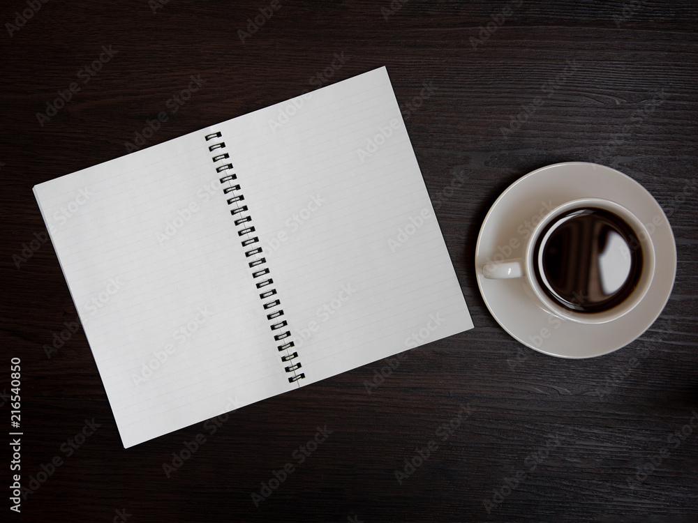 Top view of coffee cup and blank notebook for memo on wooden background. Business and object concept. Memo and reminder theme. Top view of coffee cup and blank notebook for memo on wooden background. Business and object concept. Memo and reminder theme.