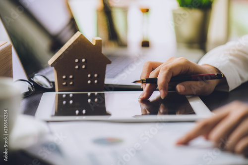 Hand of Business people calculating interest, taxes and profits to invest in real estate and home buying