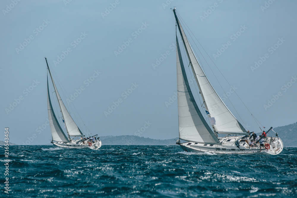 Two yachts sail boats racing in a blue sea