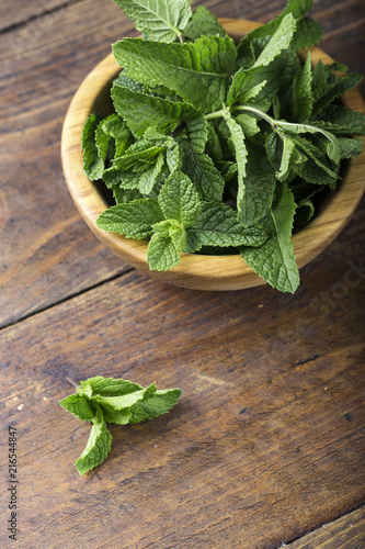 mint in a plate on a wooden background