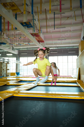 beautiful little girl jumping on a trampoline in a game club