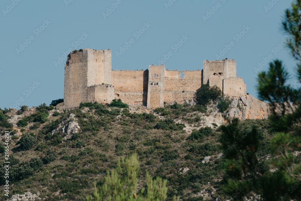 An ancient castle on the pick of the hill in Spain in the evening. El Castillo de Chirel. 
