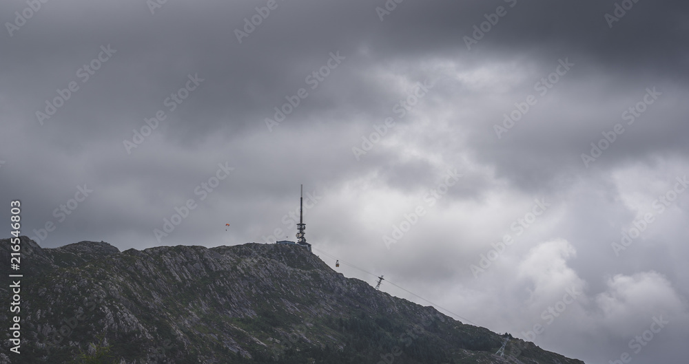Ulriken in Bergen. Man in parachute in the distance