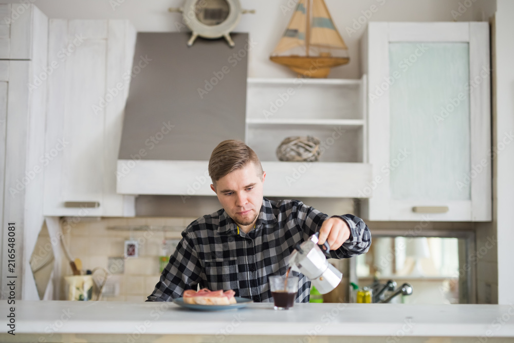Morning, drink and people concept - Portrait of handsome man pouring coffee in a coffee mug at the kitchen Morning, drink and people concept - Portrait of handsome man pouring coffee in a coffee mug at the kitchen