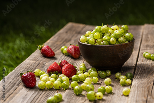strawberries and gooseberries in the garden on the table