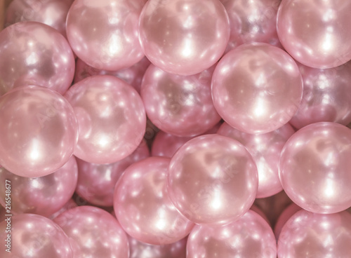 Cutout texture closeup on multiple pink shiny pearls.