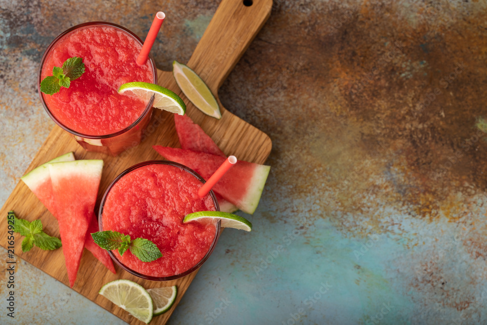 Watermelon slushie with lime, summer refreshing drink in tall glasses on a blue rusty background. Top view with copy space Watermelon slushie with lime, summer refreshing drink in tall glasses on a blue rusty background. Top view with copy space