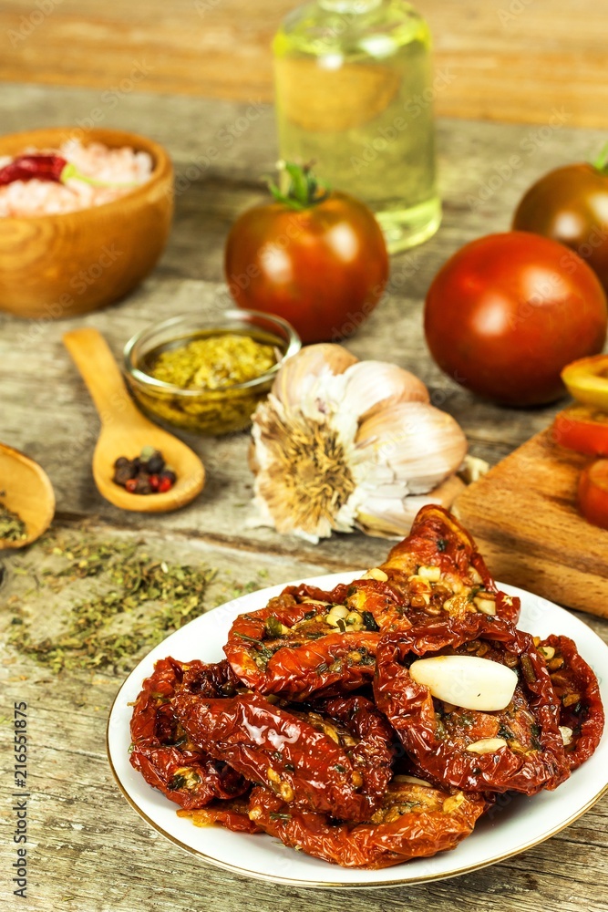 Dried tomatoes pickled in olive oil with garlic. Sunflower seeds with tomatoes on an old wooden table. Dried tomatoes pickled in olive oil with garlic. Sunflower seeds with tomatoes on an old wooden table.
