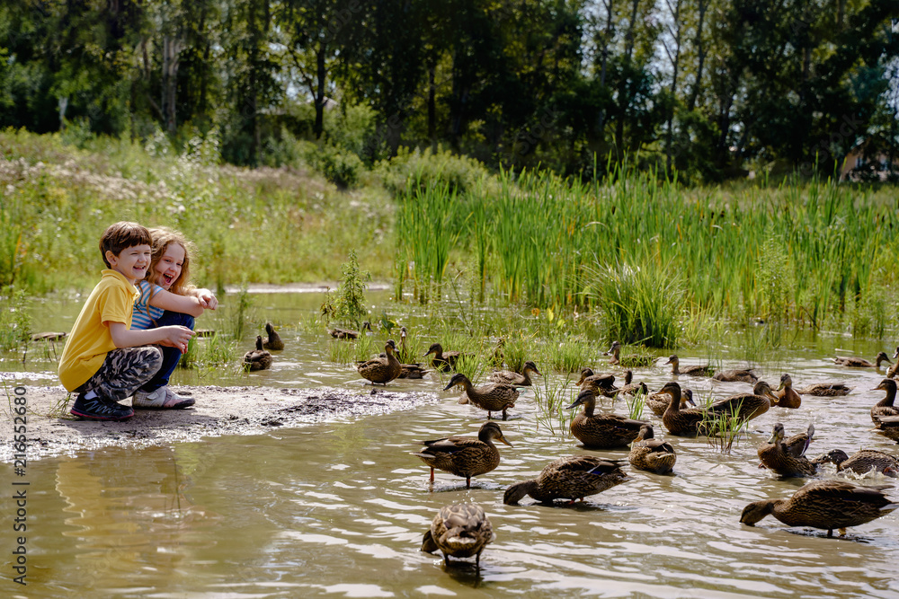 Children feeding ducks on abandoned lake. Children feeding ducks on abandoned lake.