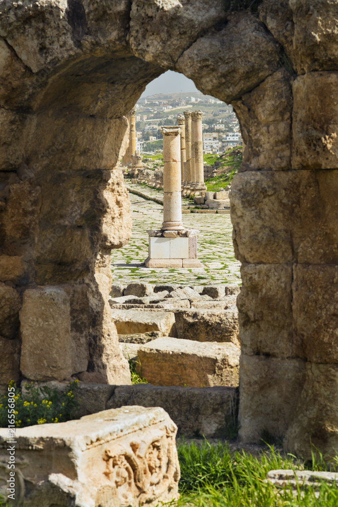 view to ruin of old greek columns through arch