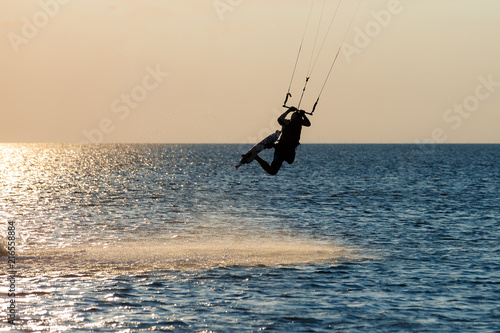 professional kiter doing a complicated trick on a beautiful sunset background