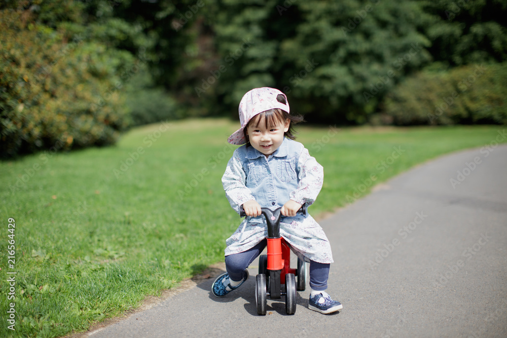 baby girl play bike at Summer forest park baby girl play bike at Summer forest park