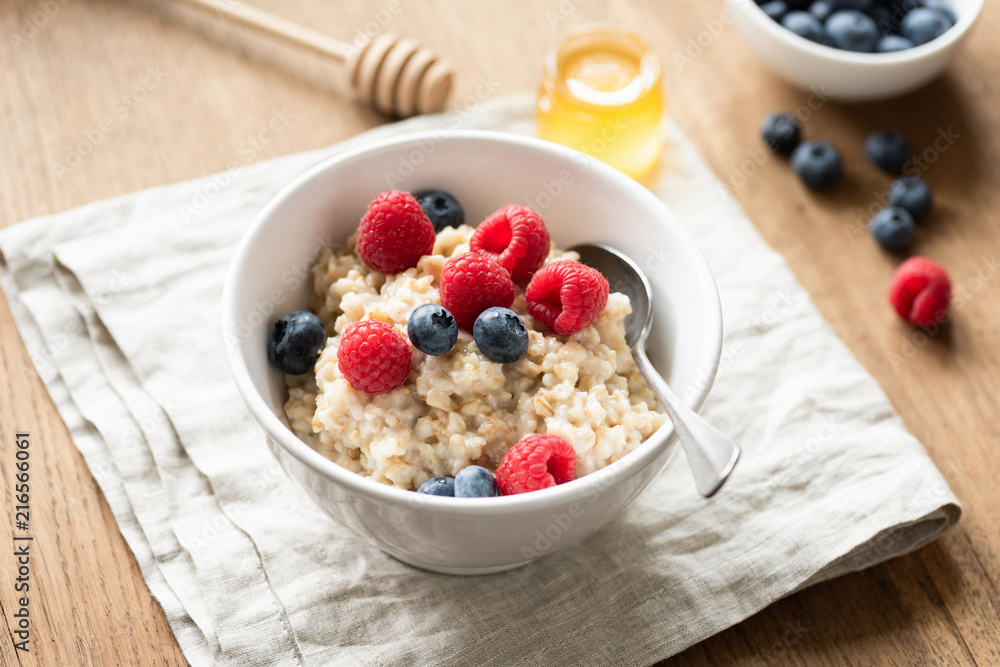 Oats porridge with fresh berries in a bowl, selective focus Oats porridge with fresh berries in a bowl, selective focus