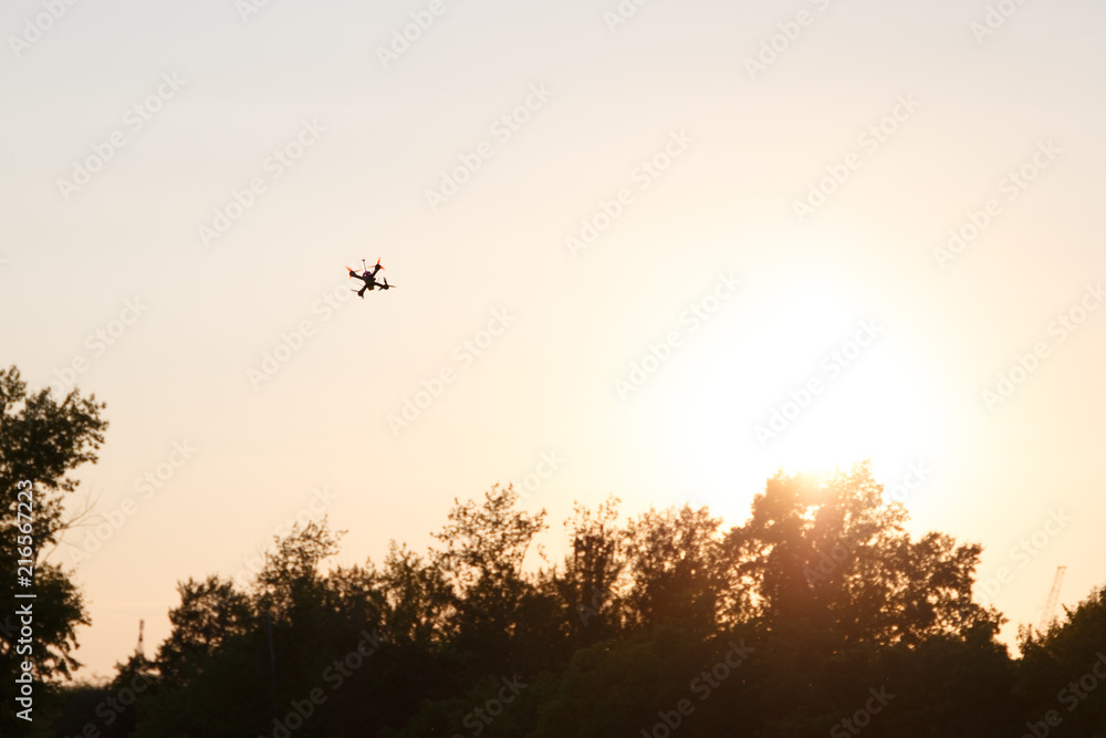 Drone on the background of the sunset sky. Silhouette drone against the background of the sunset. Flying drones in the evening sky