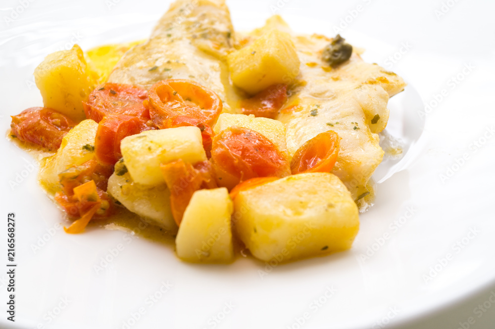 fish dish, cod with tomato, potatoes and capers, cooked in a pan. fish dish, cod with tomato, potatoes and capers, cooked in a pan.