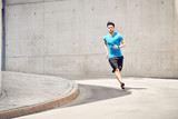 Fit man running during workout session in the city. Health and sport concept