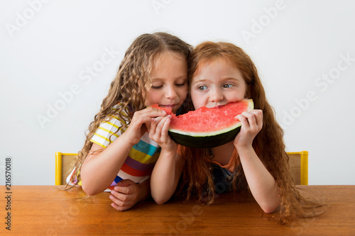Little girls sharing a slice of watermelon