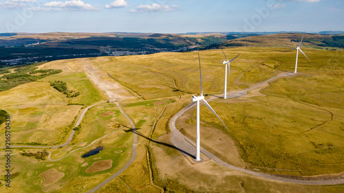 Large wind turbines on a dry, remote, rural hillside photo